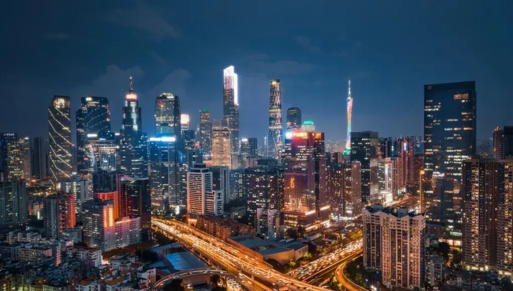 Night-view-of-Guangzhou-skyline-with-illuminated-skyscrapers-and-busy-highway-interchange