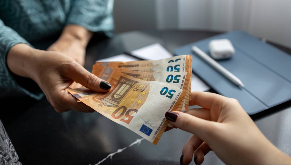 financial-problems-and-debts-woman-handing-woman-euro-banknotes-european-union-currency-fifty-euro-banknote-stockpack-gettyimages